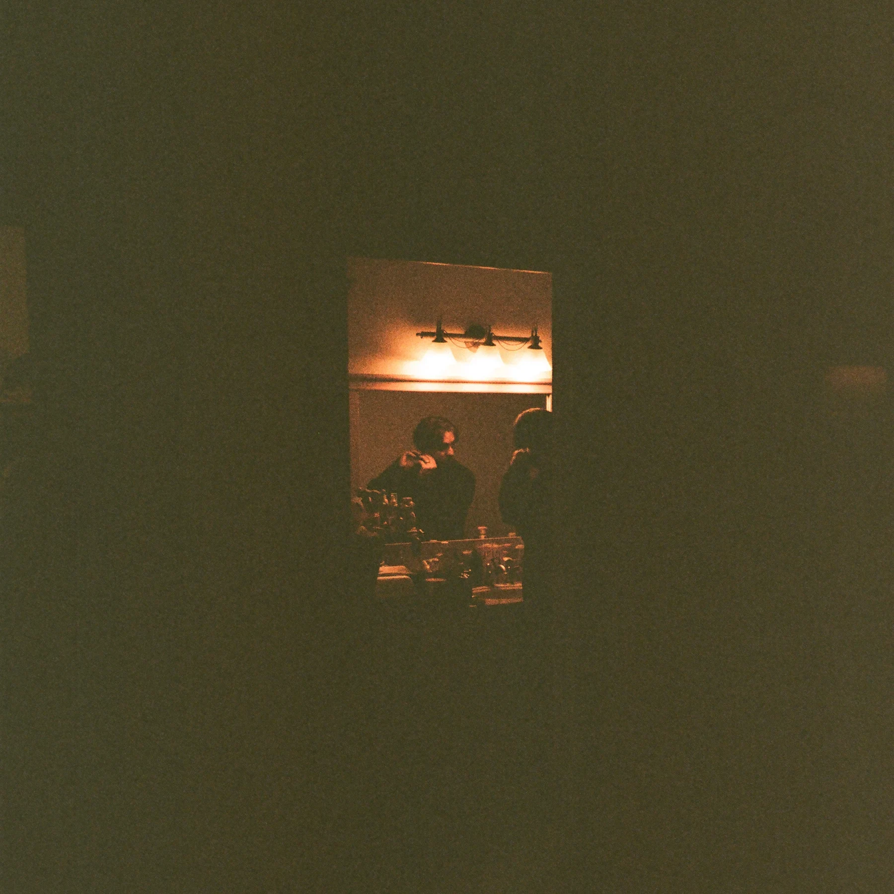 A small illuminated window surrounded by darkness
