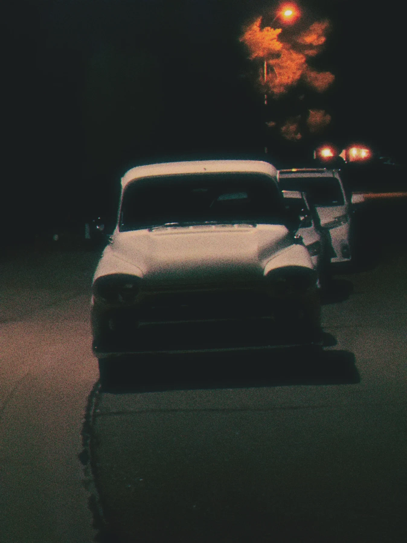 A parked car beneath lights at night