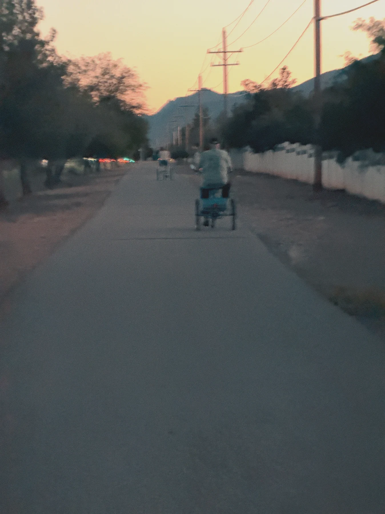 A person walking along a quiet street at dusk